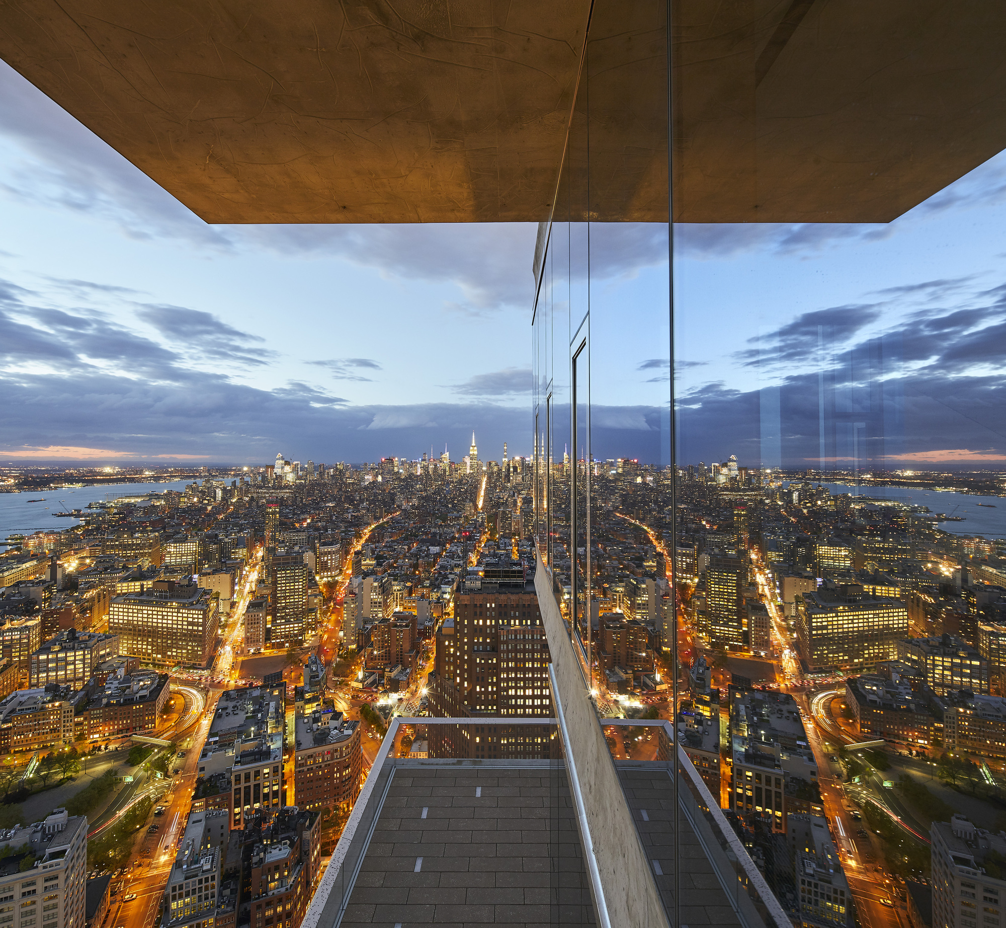 Floor-to-ceiling glass interior with panoramic Manhattan views